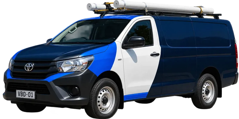 A licensed Leichhardt plumbing van loaded with pipe on the roof rack